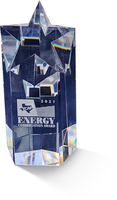 A crystal trophy with a star-shaped top, engraved with the TCA logo, "2021 ENERGY CONSERVATION AWARD," and reflecting colorful light along its edges.